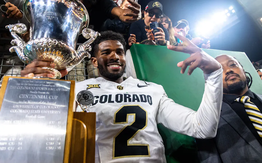 Colorado quarterback Shedeur Sanders poses with the Centennial Cup after beating Colorado State in the Rocky Mountain Showdown.