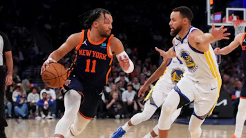 Jalen Brunson #11 of the New York Knicks drives to the basket against Stephen Curry as we look at the best NBA player props & best bets for Knicks vs. Warriors