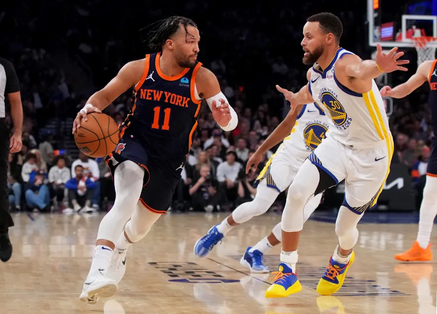 Jalen Brunson #11 of the New York Knicks drives to the basket against Stephen Curry as we look at the best NBA player props & best bets for Knicks vs. Warriors