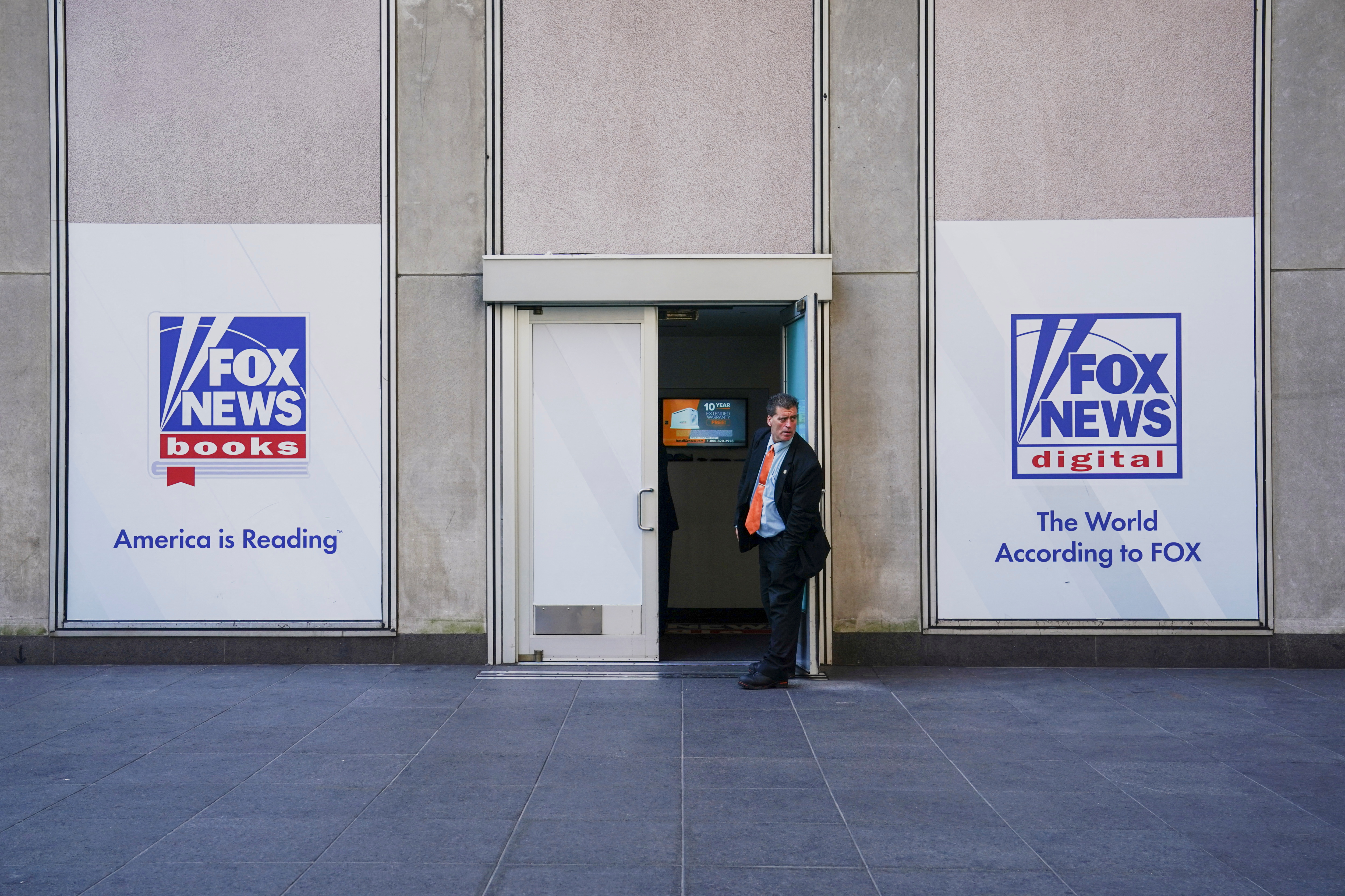 A  man guards a side door to the News Corporation building as we look at its deal with Kalshi.