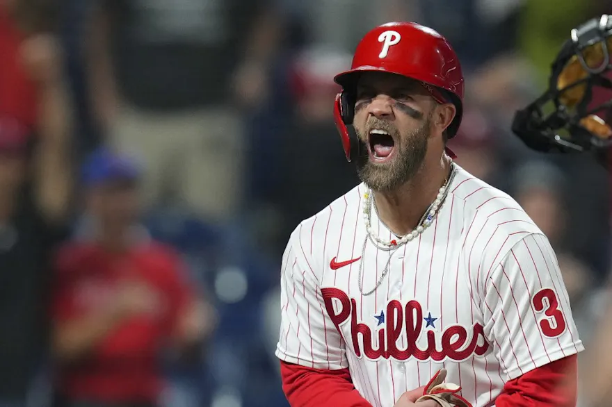 Bryce Harper of the Philadelphia Phillies reacts after scoring the game-winning run against the Miami Marlins, and we offer our top predictions for Braves vs. Phillies NLDS Game 4 based on the best MLB odds.