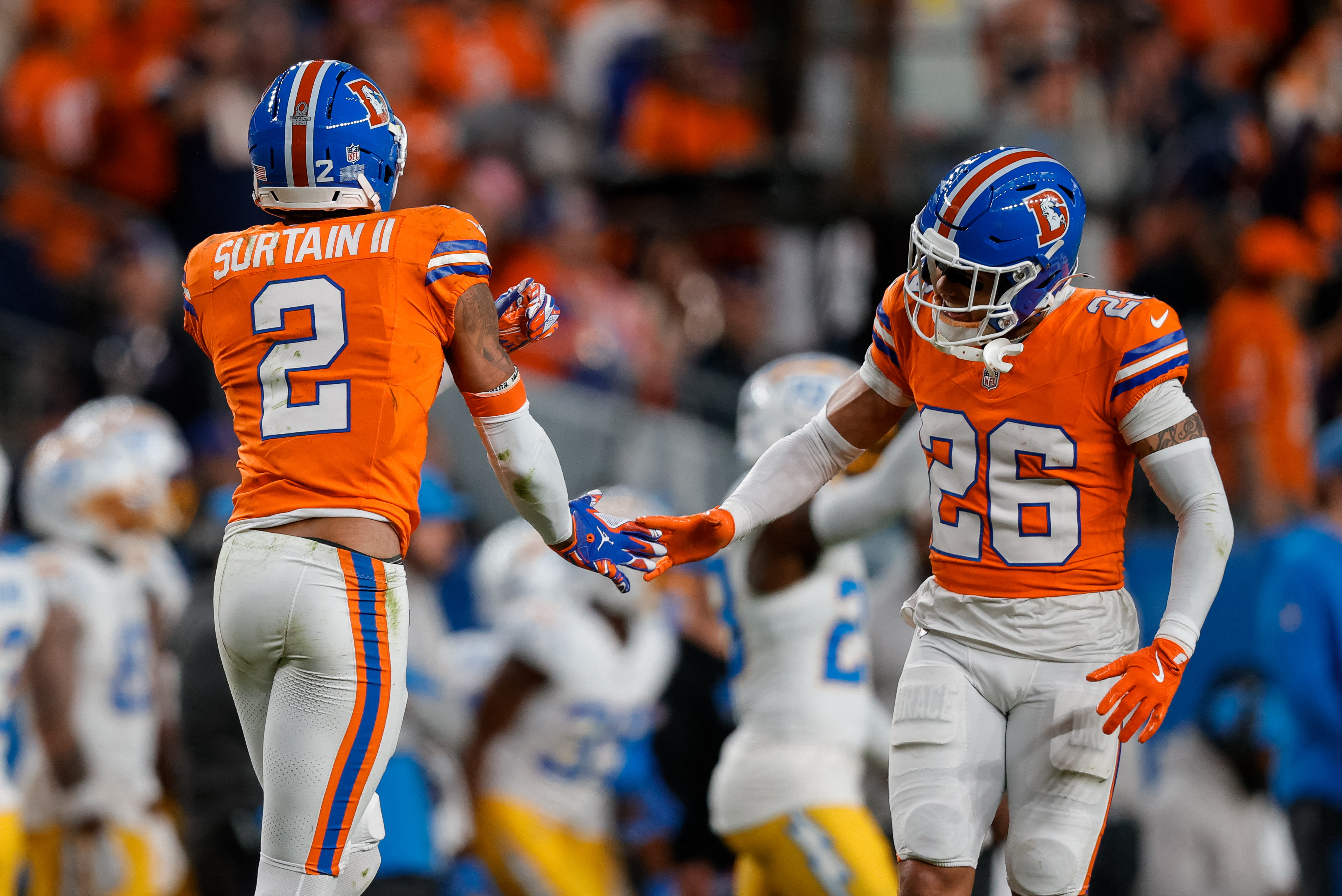 Pat Surtain II reacts with safety Devon Key as we provide the AFC Championship odds and betting lines. 