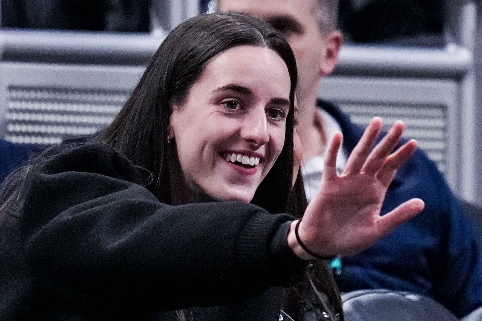 Indiana Fever guard Caitlin Clark waves to her former teammates in a round one game at the 2025 TIAA Big Ten Women's Basketball Tournament.