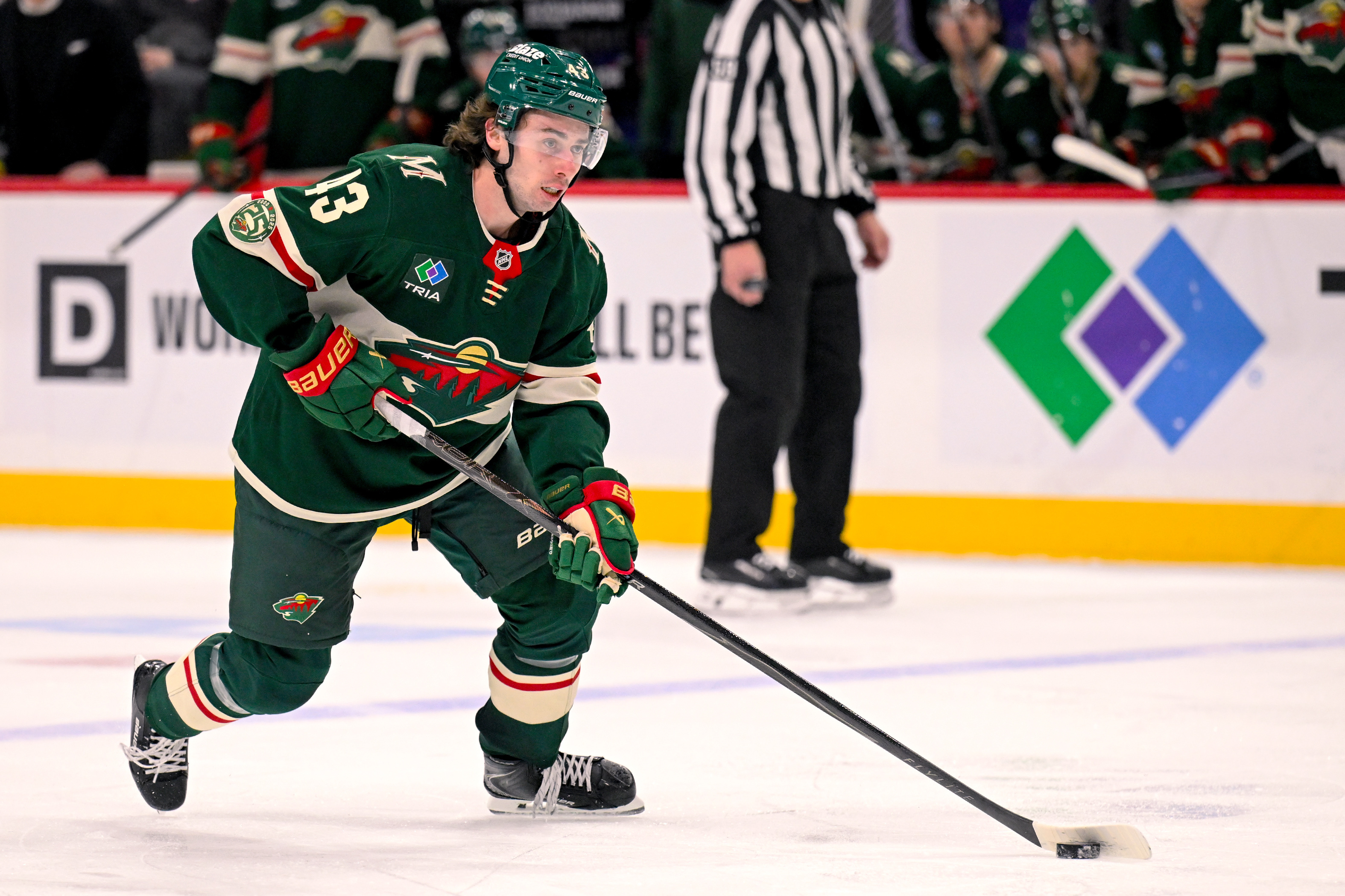 Minnesota Wild defensemen Quinn Hughes controls the puck.