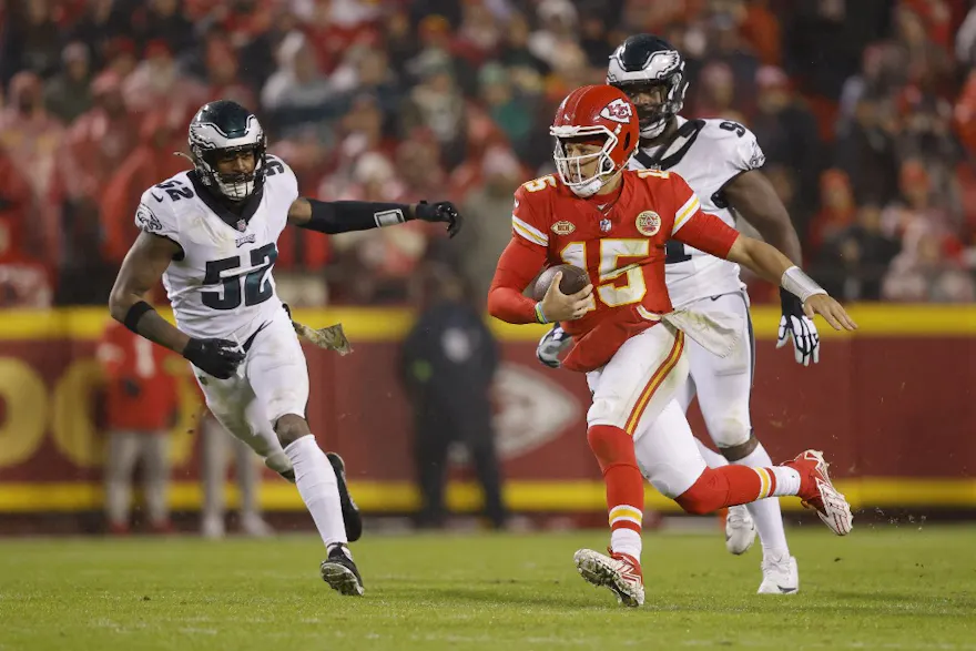 Patrick Mahomes of the Kansas City Chiefs scrambles ahead of our Week 12 NFL predictions for Chiefs vs. Raiders 