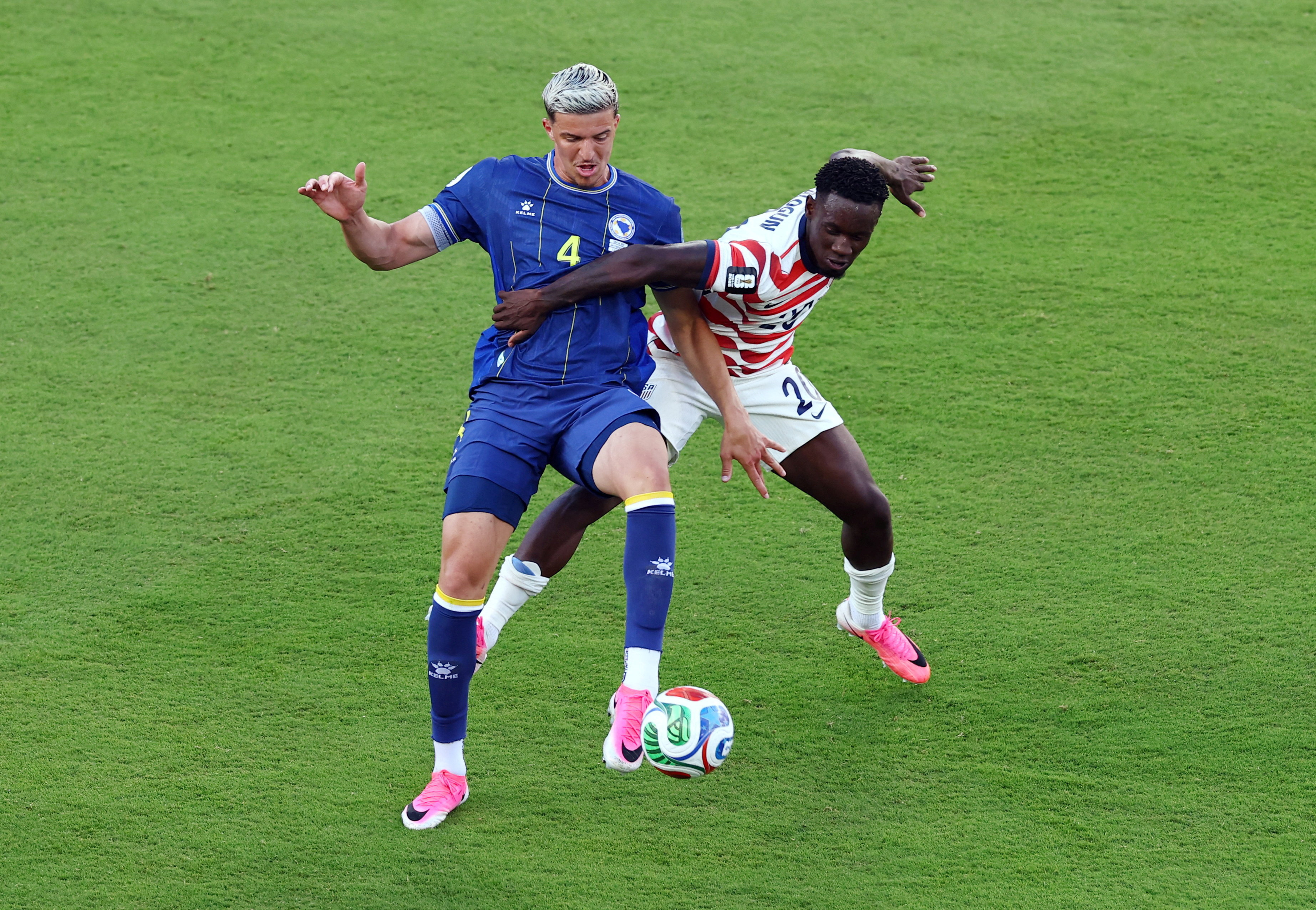 Folarin Balogun of the U.S. fouls Bosnia and Herzegovina's Tarik Muharemovic before being shown a red card as we look at suspicious World Cup betting. 