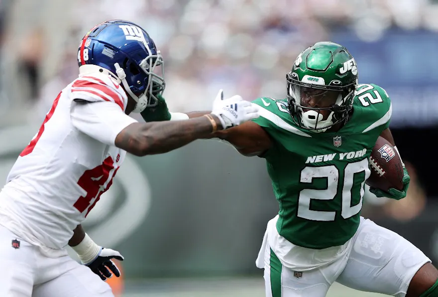 Running back Breece Hall of the New York Jets carries the ball as linebacker Tae Crowder of the New York Giants chases him, and we offer our top player props for Week 1 of the NFL season based on the best NFL odds.