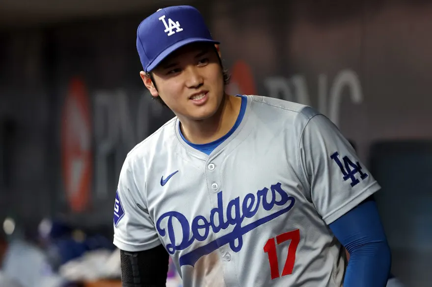Shohei Ohtani of the Los Angeles Dodgers stands in the dugout as we look at our best Dodgers vs. Reds Player Props & Expert Picks