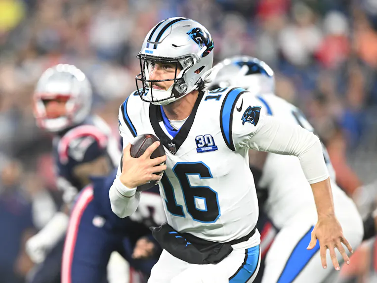 Carolina Panthers quarterback Jack Plummer runs with the ball as we look at July 2024's sports betting financials in North Carolina.