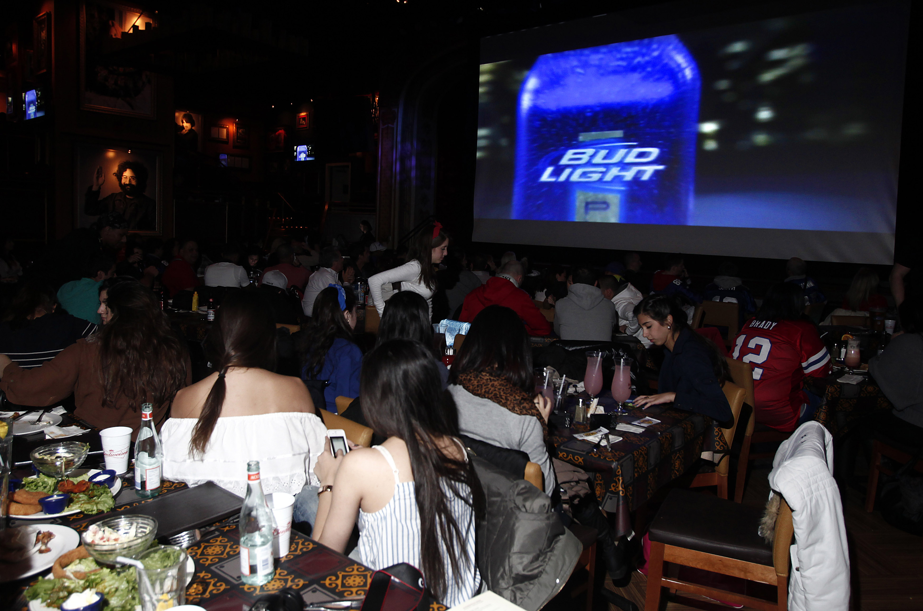 Fans watch a Bud Light commercial during the Super Bowl as we look at prediction markets for Super Bowl 2026 brands.