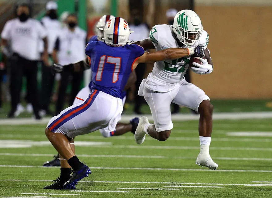 Tra Fluellen of the Houston Baptist Huskies tries to stop the run by Oscar Adaway III of the North Texas Mean Green during a game at Apogee Stadium.