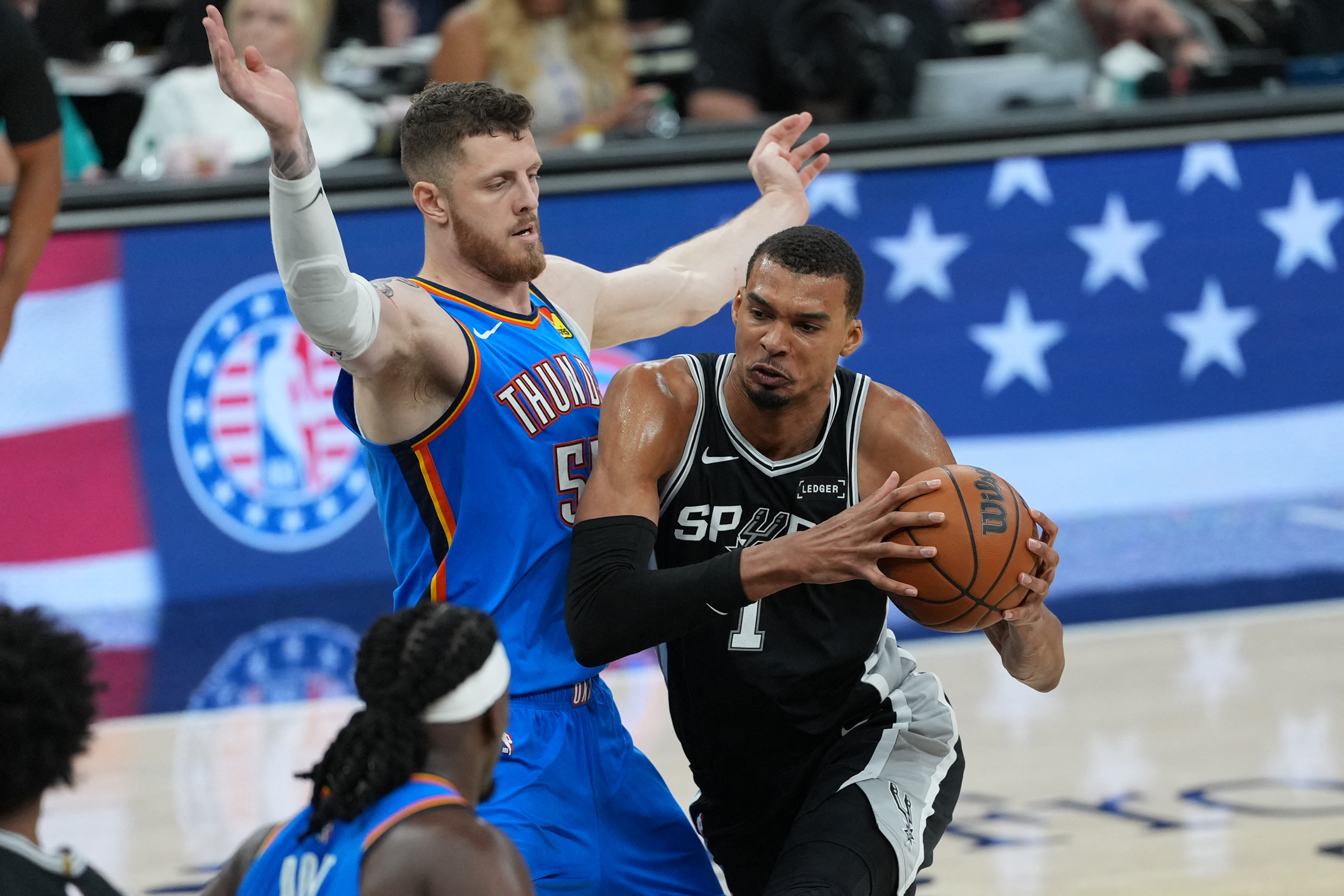 San Antonio Spurs forward Victor Wembanyama (1) dribbles the ball past Oklahoma City Thunder center Isaiah Hartenstein (55), and both are featured in our Thunder vs. Spurs player props today.