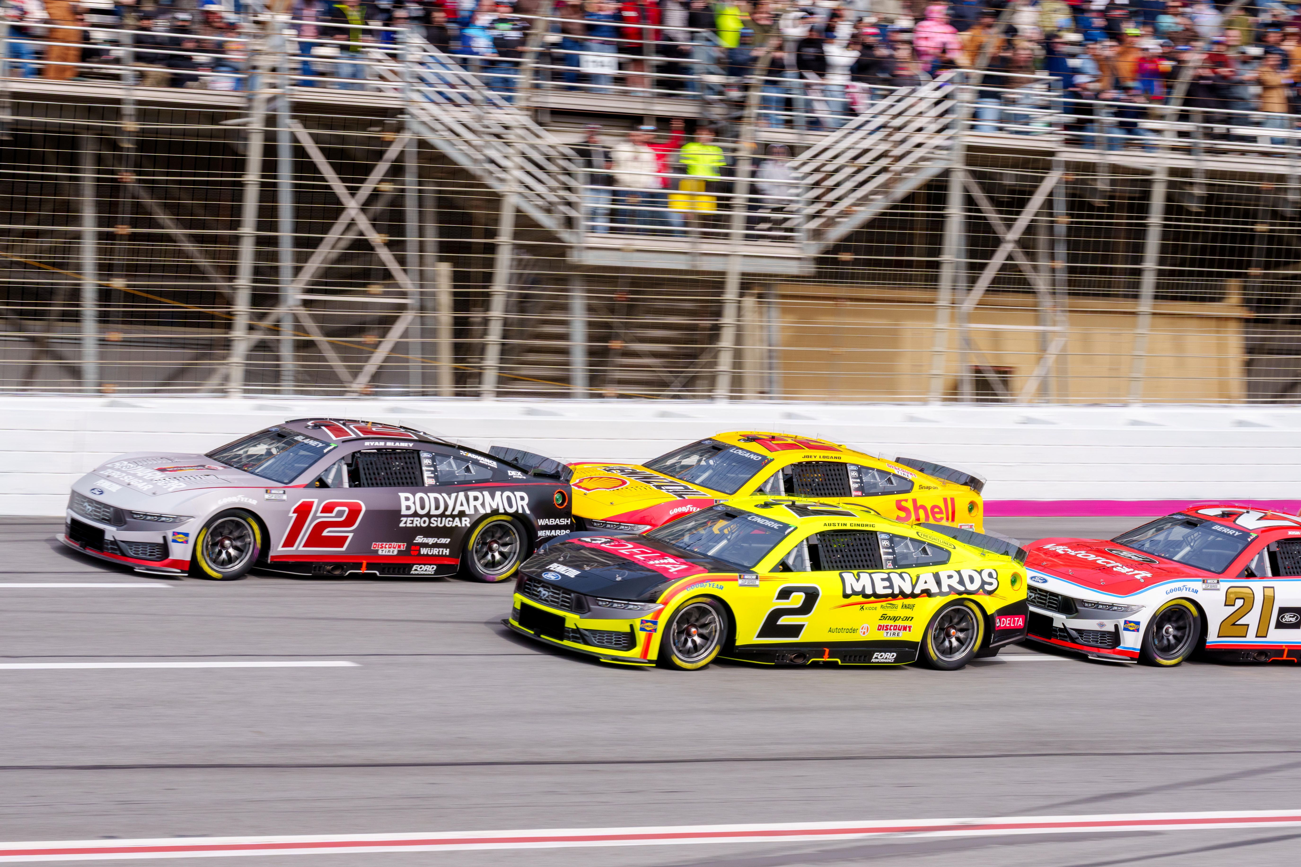 Ryan Blaney (12) and Austin Cindric (2), who leads our Autotrader 400 predictions for Sunday's NASCAR race at Atlanta, lead the pack through turn four at Atlanta Motor Speedway.