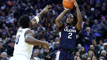 Tristen Newton UConn Huskies shoots over TJ Bamba of the Villanova Wildcats. The UConn Huskies remain the favorites in the March Madness odds.