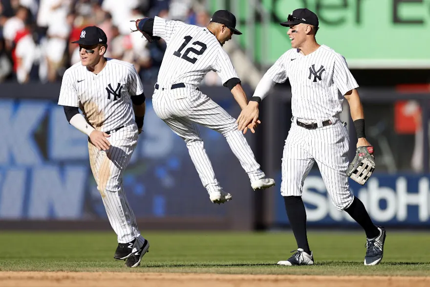 Harrison Bader, Isiah Kiner-Falefa, and Aaron Judge of the New York Yankees celebrate during the ninth inning against the Boston Red Sox.