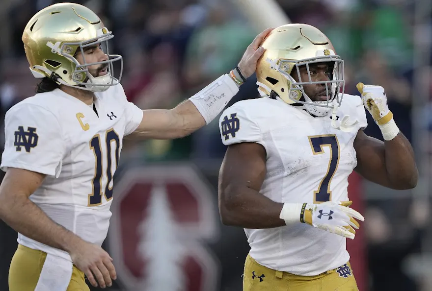 Sam Hartman and Audric Estime of the Notre Dame Fighting celebrate after Estime scored a touchdown against the Stanford Cardinal, and we offer our top Oregon State vs. Notre Dame prediction for the Sun Bowl based on the best NCAAF odds.