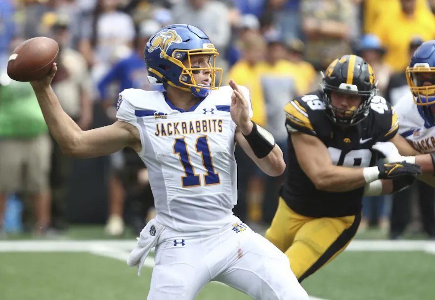 Quarterback Mark Gronowski of the South Dakota State Jackrabbits throws while under pressure from defensive lineman Ethan Hurkett of the Iowa Hawkeyes. South Dakota State is the expected favorite by the 2025 College Football FCS Championship Odds.