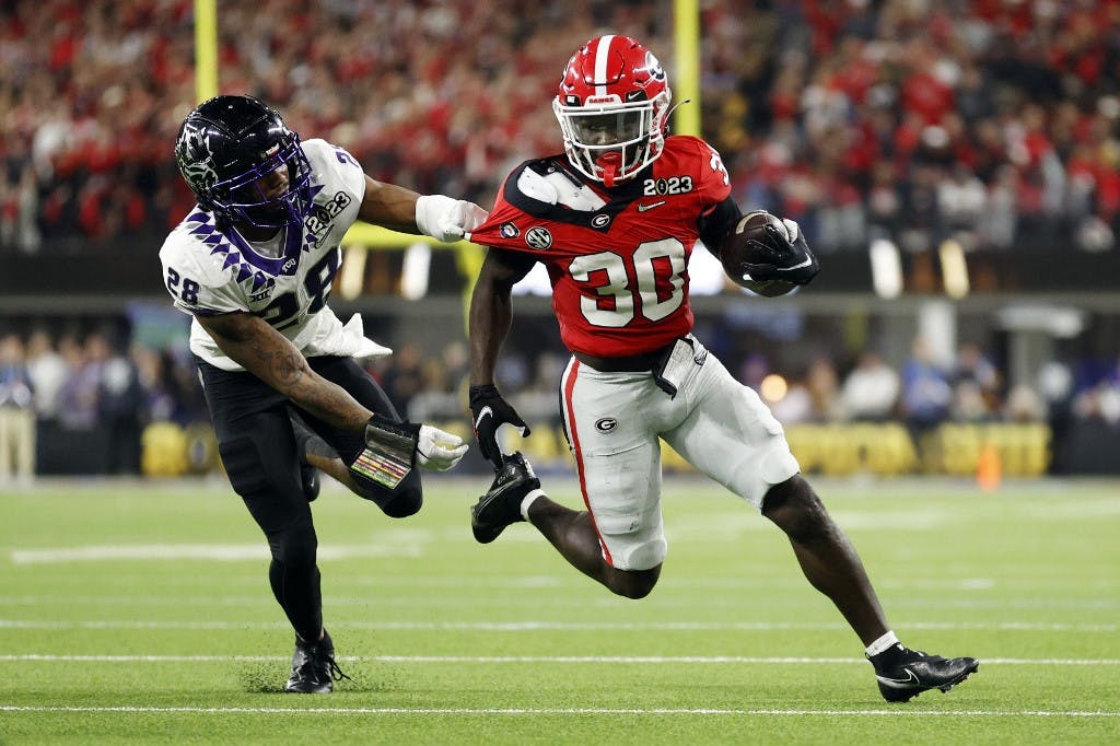 INGLEWOOD, CALIFORNIA - JANUARY 09: Daijun Edwards #30 of the Georgia Bulldogs runs with the ball against Millard Bradford #28 of the TCU Horned Frogs in the second quarter during the College Football Playoff National Championship game at SoFi Stadium on January 09, 2023 in Inglewood, California.