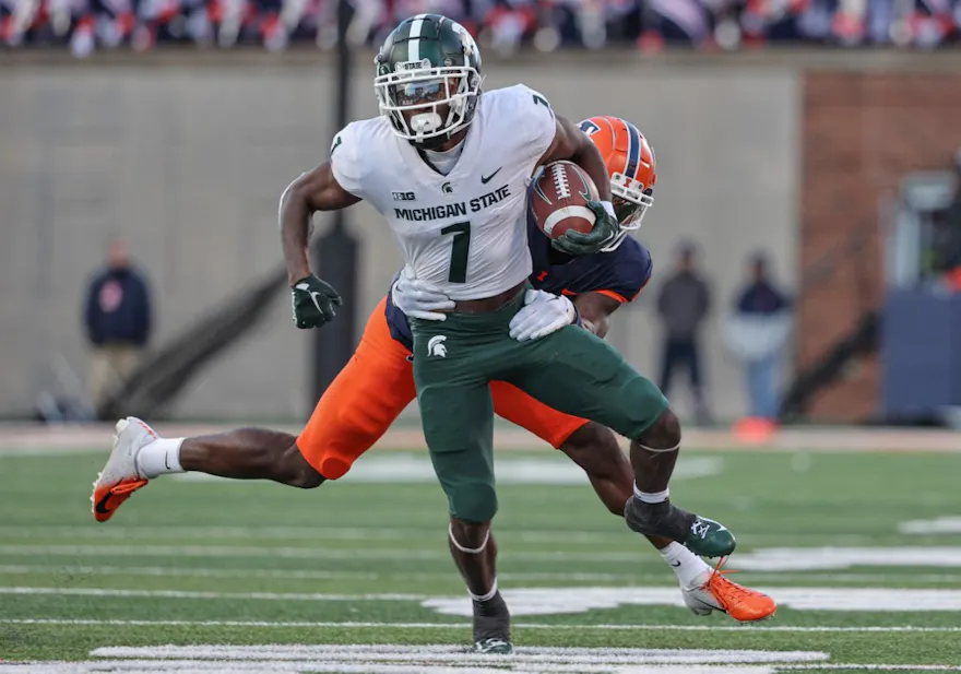 Jayden Reed of the Michigan State Spartans runs the ball as Jartavius Martin of the Illinois Fighting Illini tries to make the tackle from behind during the second half at Memorial Stadium on November 5, 2022 in Champaign, Illinois.