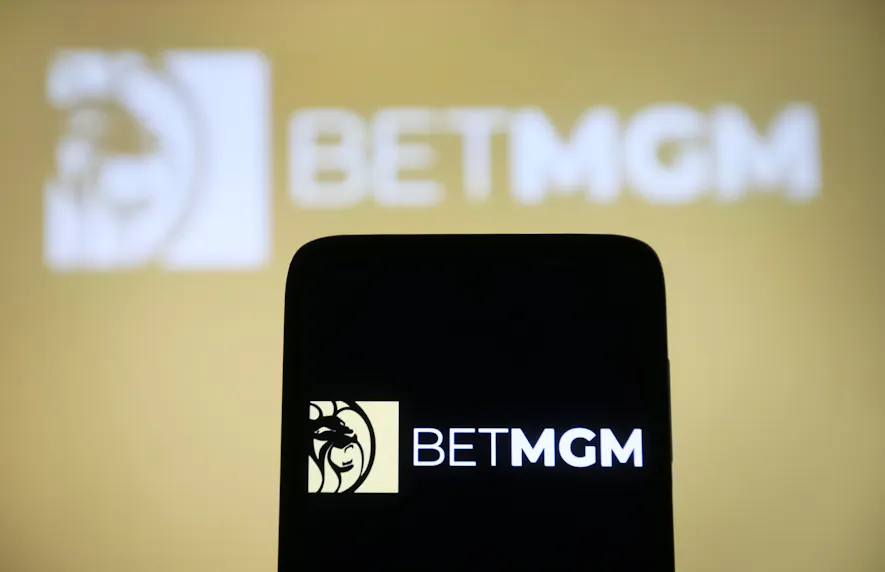 In this photo illustration, a BetMGM logo is seen on a smartphone and in the background as we look at their single rewards account.
