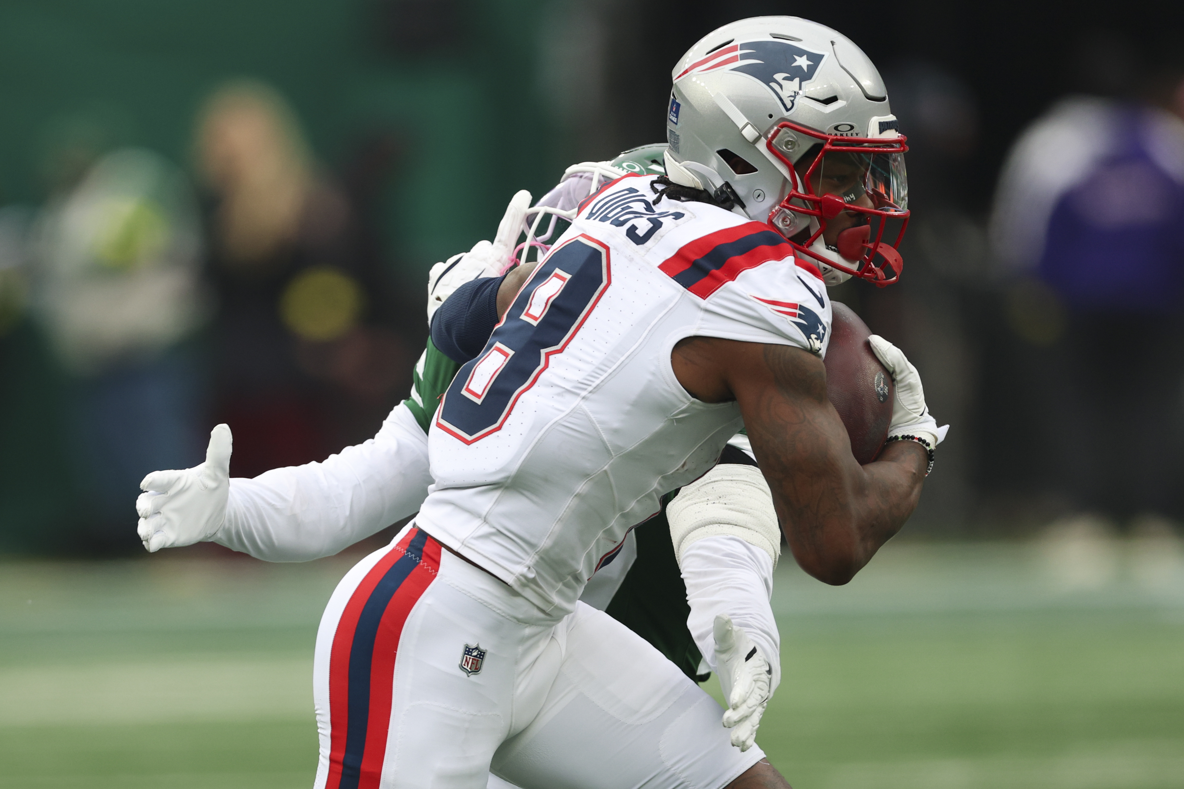 New England Patriots wide receiver Stefon Diggs makes a reception as New York Jets safety Malachi Moore tackles during the second quarter of the game at MetLife Stadium. 