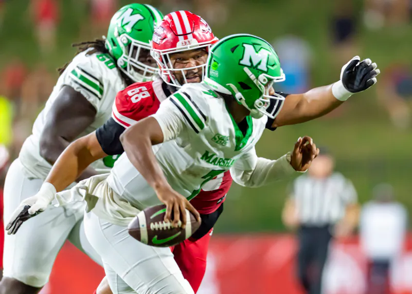 Marshall QB Carlos Del Rio-Wilson 7 scrambles in an attempt to evade a defender as we look at our college football player prop bets