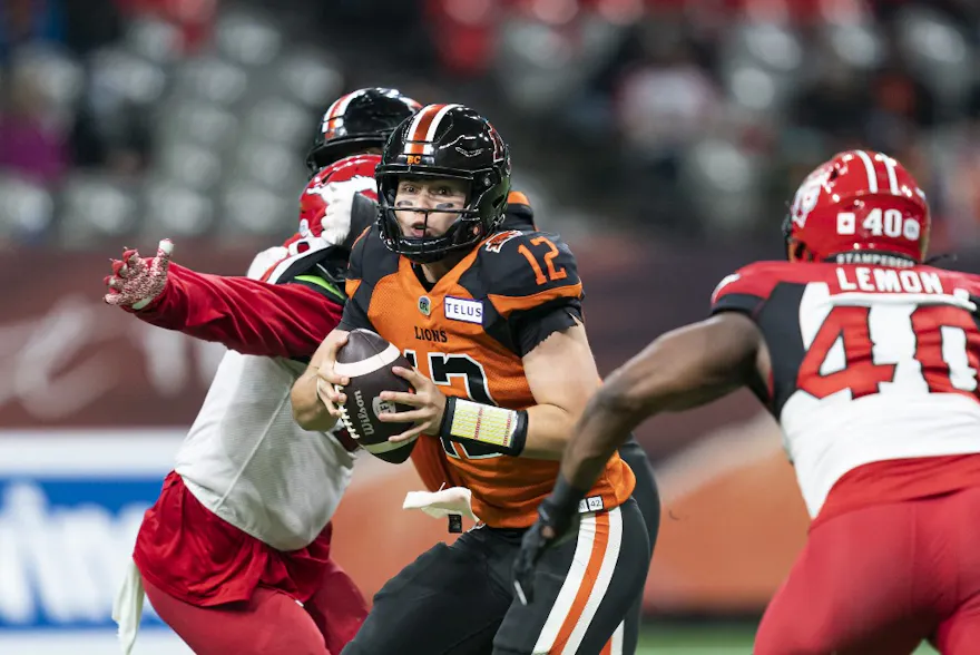 Quarterback Nathan Rourke of the BC Lions scrambles while being pressured by Shawn Lemon of the Calgary Stampeders at BC Place on Oct. 16, 2021 in Vancouver, British Columbia.