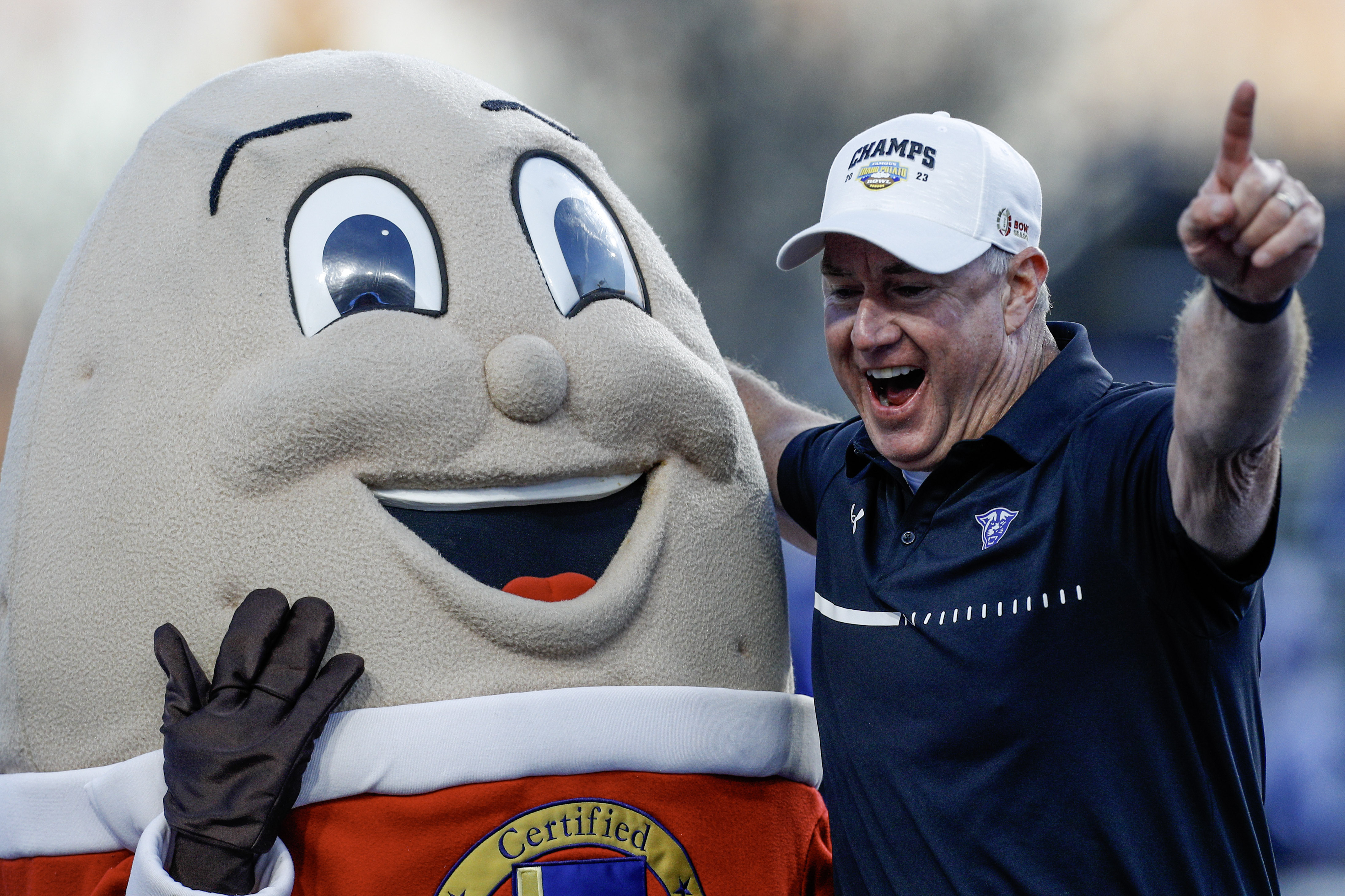 Former Georgia State head coach Shawn Elliott celebrating a Famous Idaho Potato Bowl win with Spuddy Buddy, one of the most beloved mascots in our college football bowl mascot rankings.