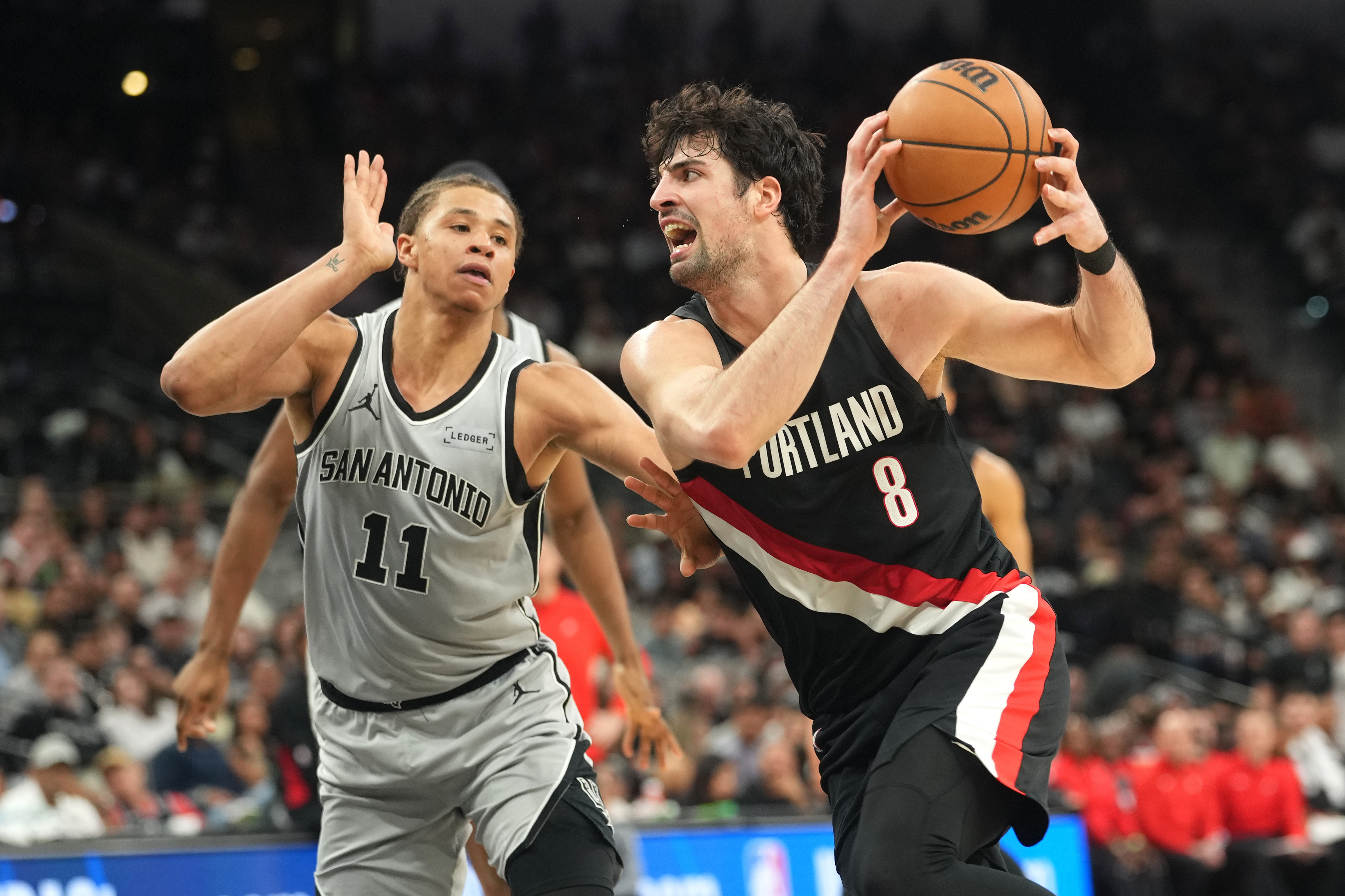 Portland Trail Blazers forward Deni Avdija (8) drives to the basket against San Antonio Spurs forward Carter Bryant (11) as we break down our NBA playoff predictions.