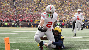 Emeka Egbuka of the Ohio State Buckeyes scores a touchdown against Ja'Den McBurrows of the Michigan Wolverines during the second quarter. The Buckeyes are the opening favorites by the 2024 Big Ten Championship Odds.