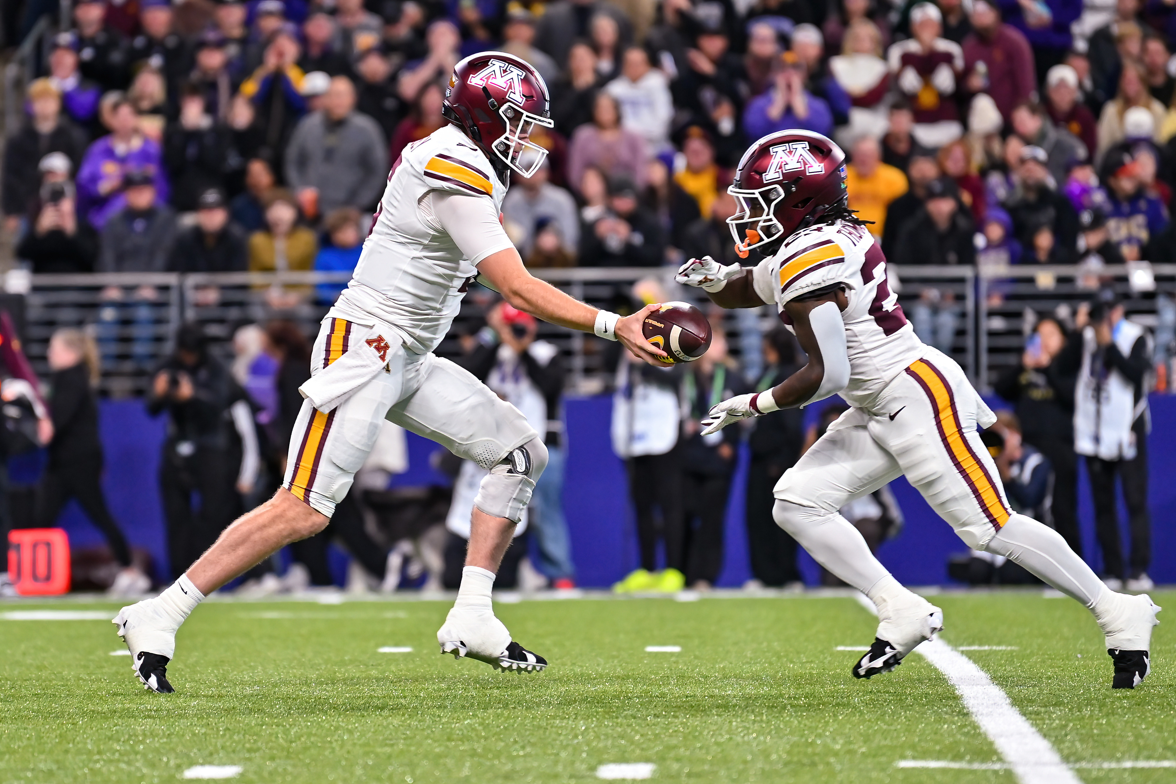 Minnesota Golden Gophers quarterback Drake Lindsey (5) hands off to Minnesota Golden Gophers running back TJ Thomas (23) as we break down our College Football player props for Week 6. 