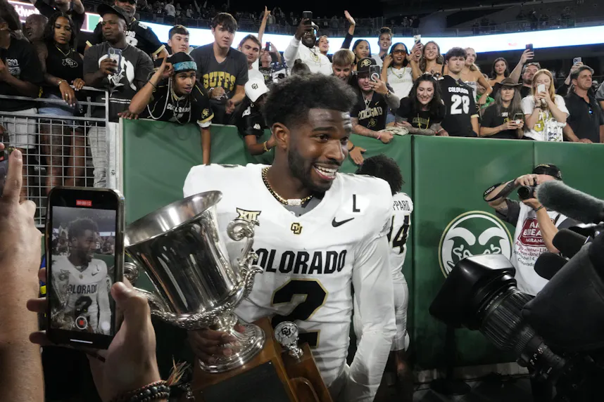 Colorado Buffaloes quarterback Shedeur Sanders celebrates with the Centennial Cup after beating the Colorado State Rams.