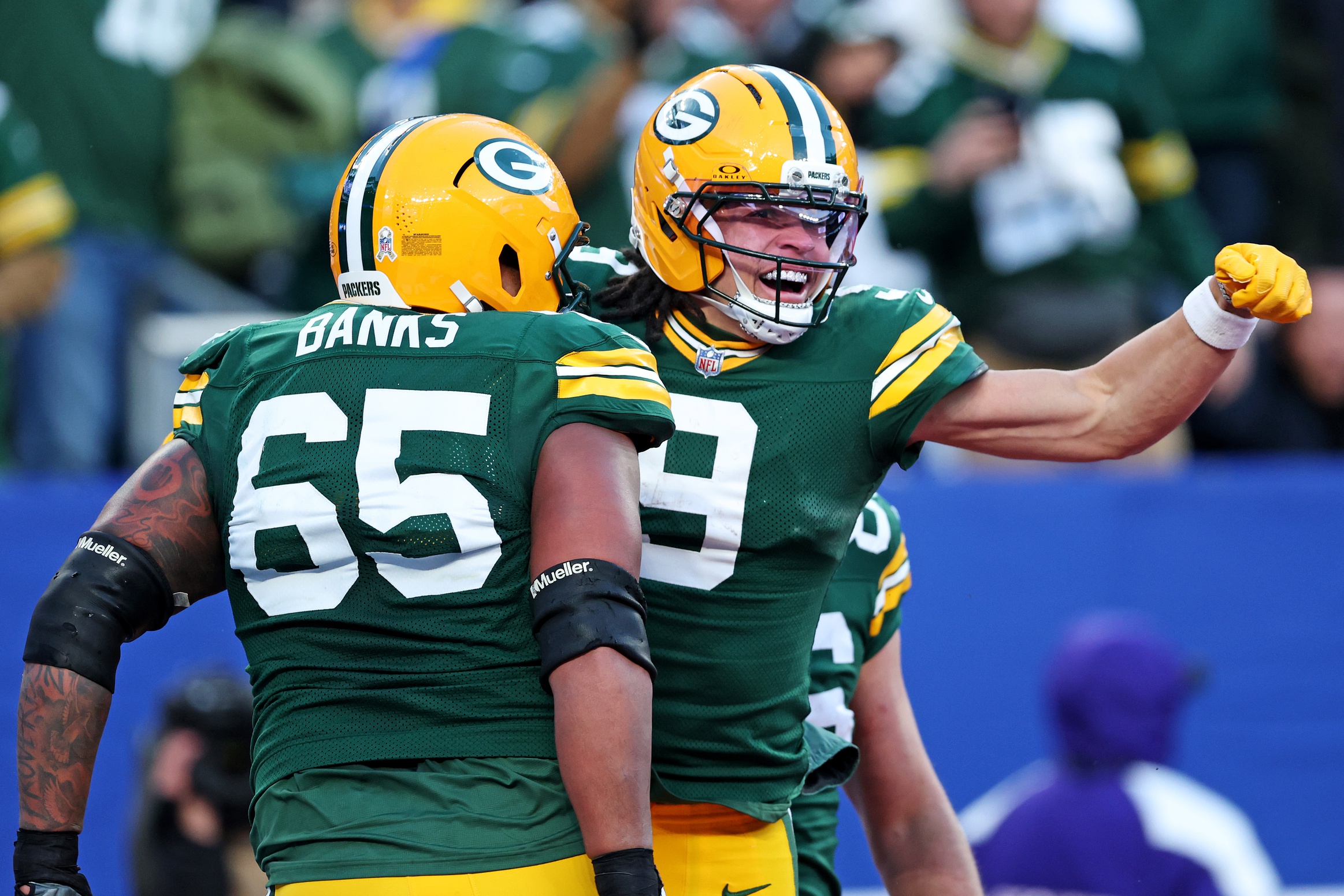 Green Bay Packers wide receiver Christian Watson celebrates with center Austin Schlottmann after scoring a touchdown, and he's key as we make our Ravens vs. Packers predictions