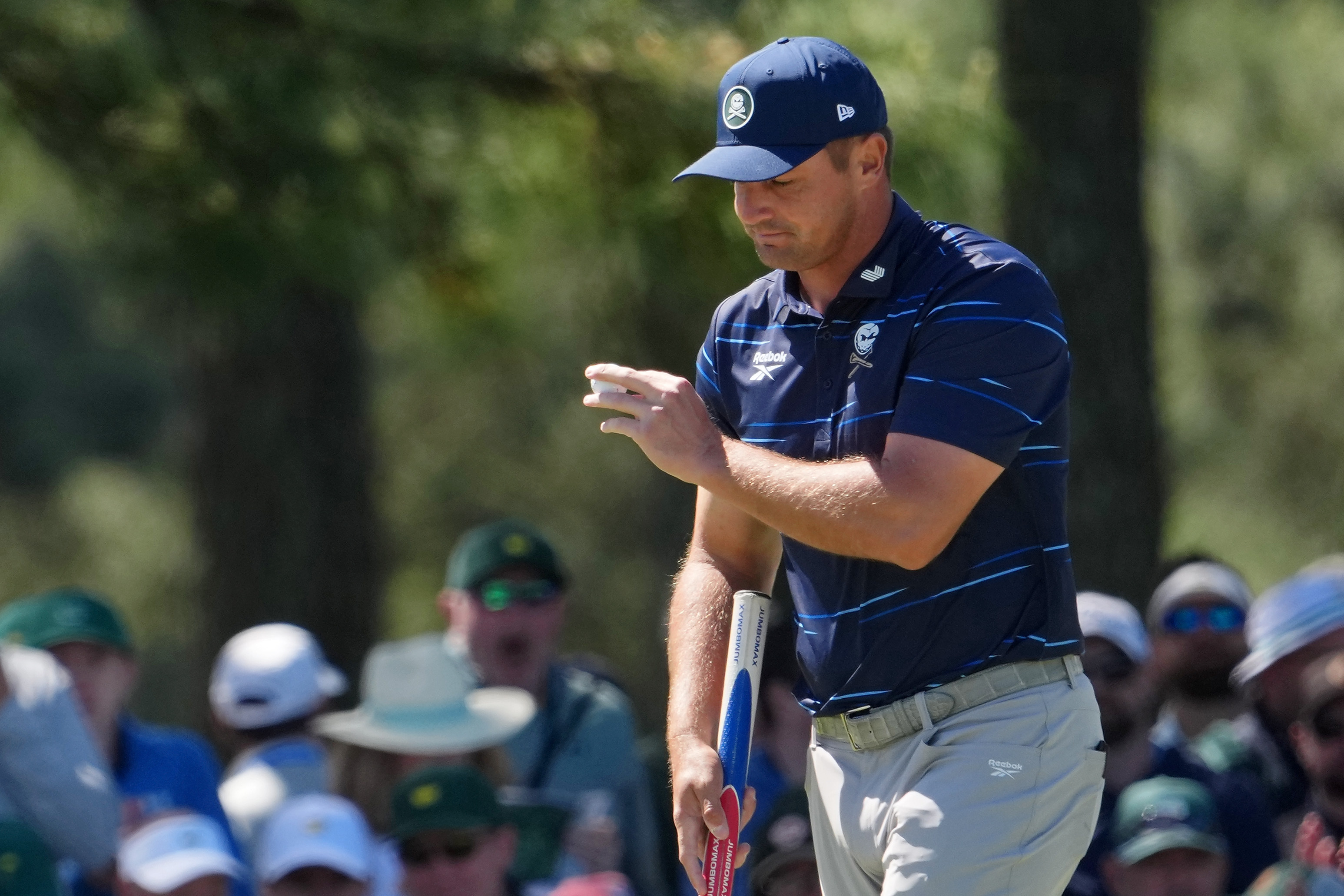 Bryson DeChambeau acknowledges patrons as he walks off the 18th green during the first round of the Masters Tournament at Augusta National Golf Club. 