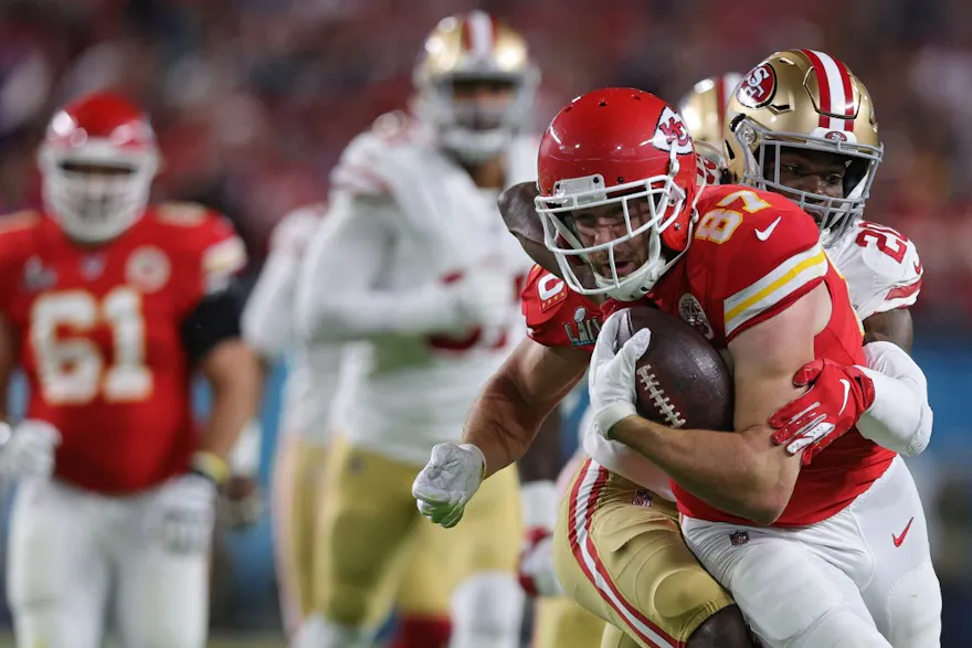 Travis Kelce #87 of the Kansas City Chiefs is tackled by Jimmie Ward #20 of the San Francisco 49ers as we look at the best Super Bowl LIV repeat props for Super Bowl 2024 featuring 49ers vs. Chiefs.