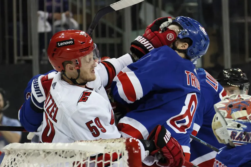 Jake Guentzel (59) of the Carolina Hurricanes gets the glove up on Jacob Trouba (8) of the New York Rangers, as we offer our best Rangers vs. Hurricanes predictions and expert picks for Thursday's Game 3 at PNC Arena in Raleigh, N.C.