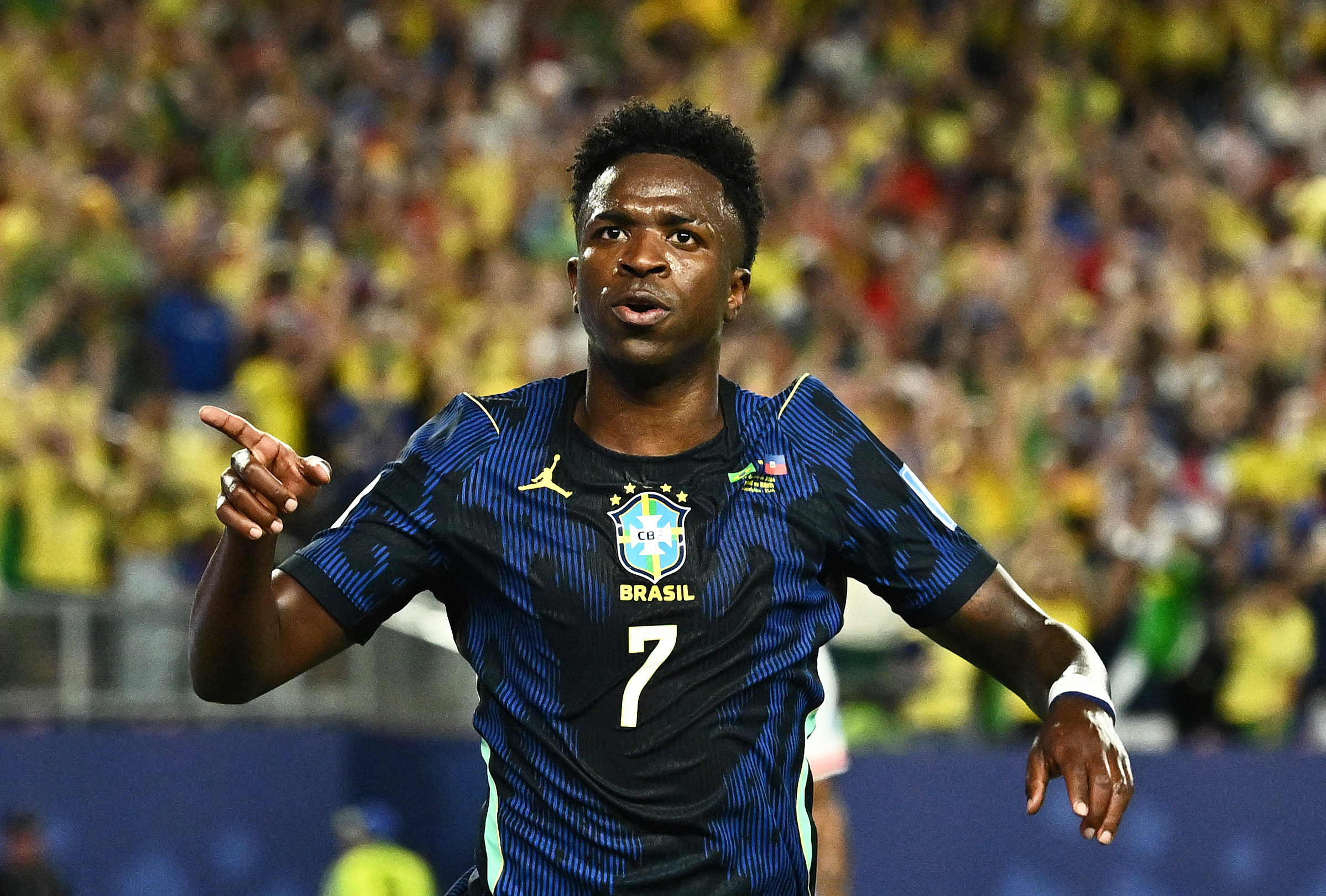 Brazil's Vinicius Junior celebrates scoring as we make our best Scotland vs. Brazil prediction. 