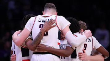 UConn Huskies players huddle as we look at our Purdue vs. UConn Parlay prediction.