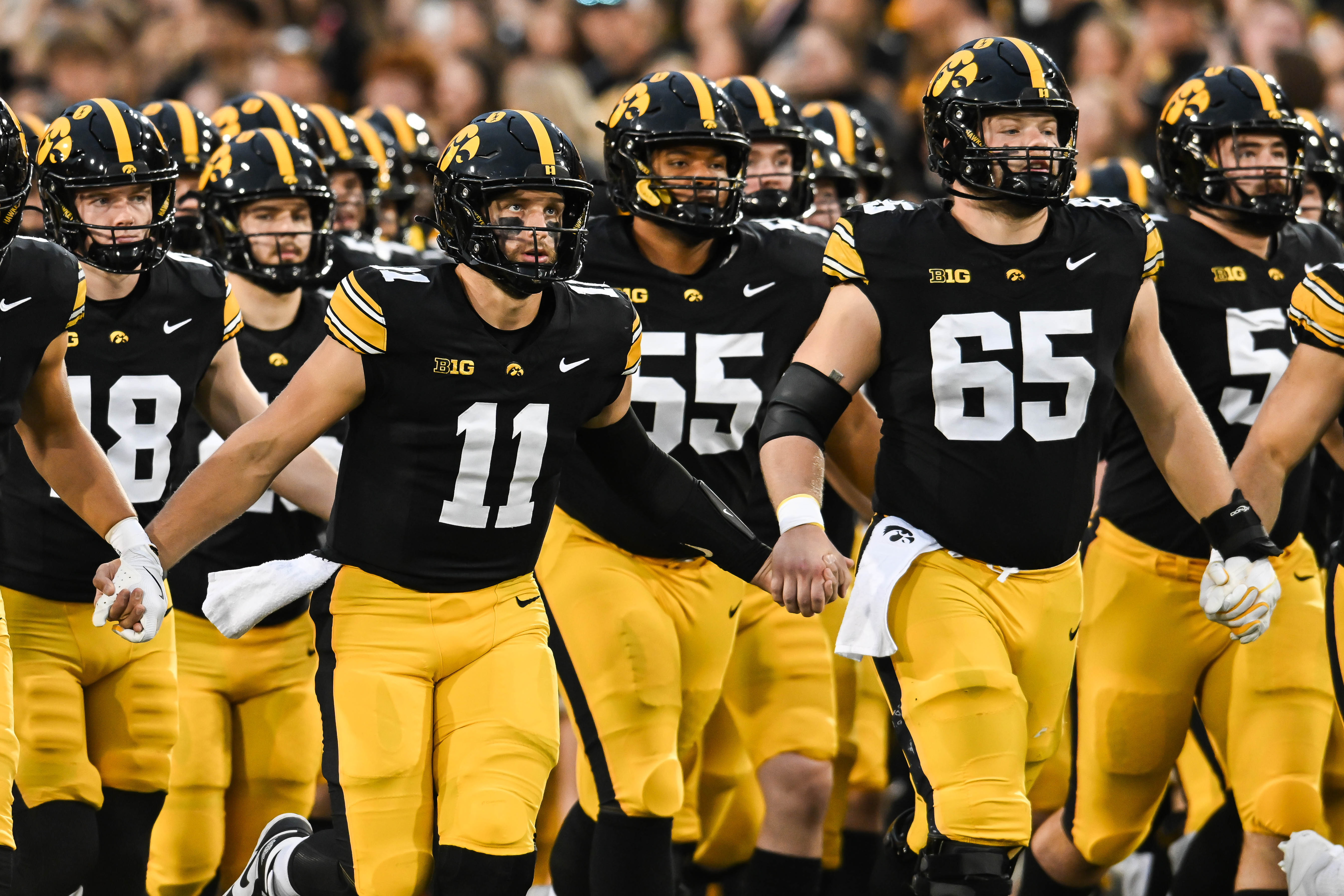 Iowa quarterback Mark Gronowski (11) and center Logan Jones (65) are key to our Iowa vs. Vanderbilt predictions for the ReliaQuest Bowl.