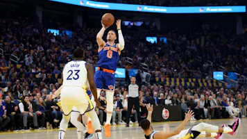Donte DiVincenzo of the New York Knicks shoots over Draymond Green and Stephen Curry of the Golden State Warriors. We're back DiVincenzo in our Knicks vs. Raptors NBA player props and Odds.