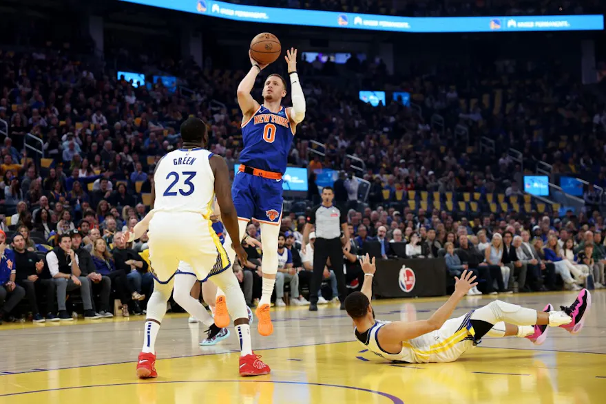 Donte DiVincenzo of the New York Knicks shoots over Draymond Green and Stephen Curry of the Golden State Warriors. We're back DiVincenzo in our Knicks vs. Raptors NBA player props and Odds.