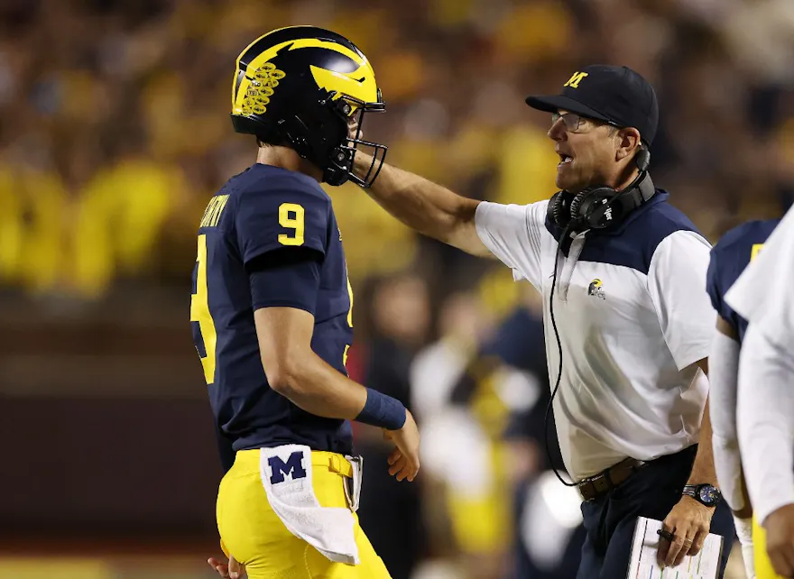 Head coach Jim Harbaugh talks to J.J. McCarthy in the first half while playing the Hawaii Warriors at Michigan Stadium on September 10, 2022 in Ann Arbor, Michigan.