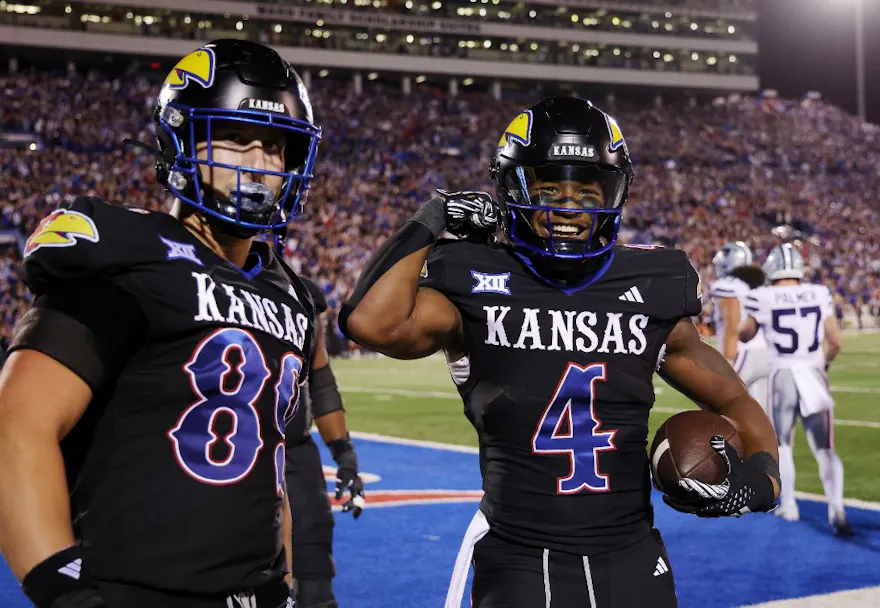 Running back Devin Neal of the Kansas Jayhawks celebrates with tight end Mason Fairchild after a touchdown as we look at our bet365 promo code for Kansas-UNLV.