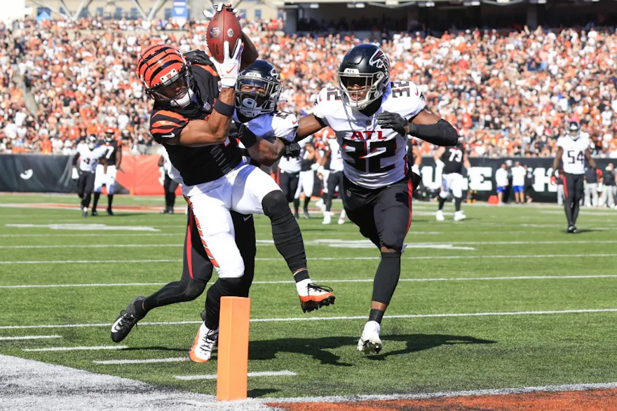 Ja'Marr Chase of the Cincinnati Bengals reaches for a touchdown after making a catch while Cornell Armstrong and Jaylinn Hawkins of the Atlanta Falcons defend at Paycor Stadium on Oct. 23, 2022 in Cincinnati, Ohio.