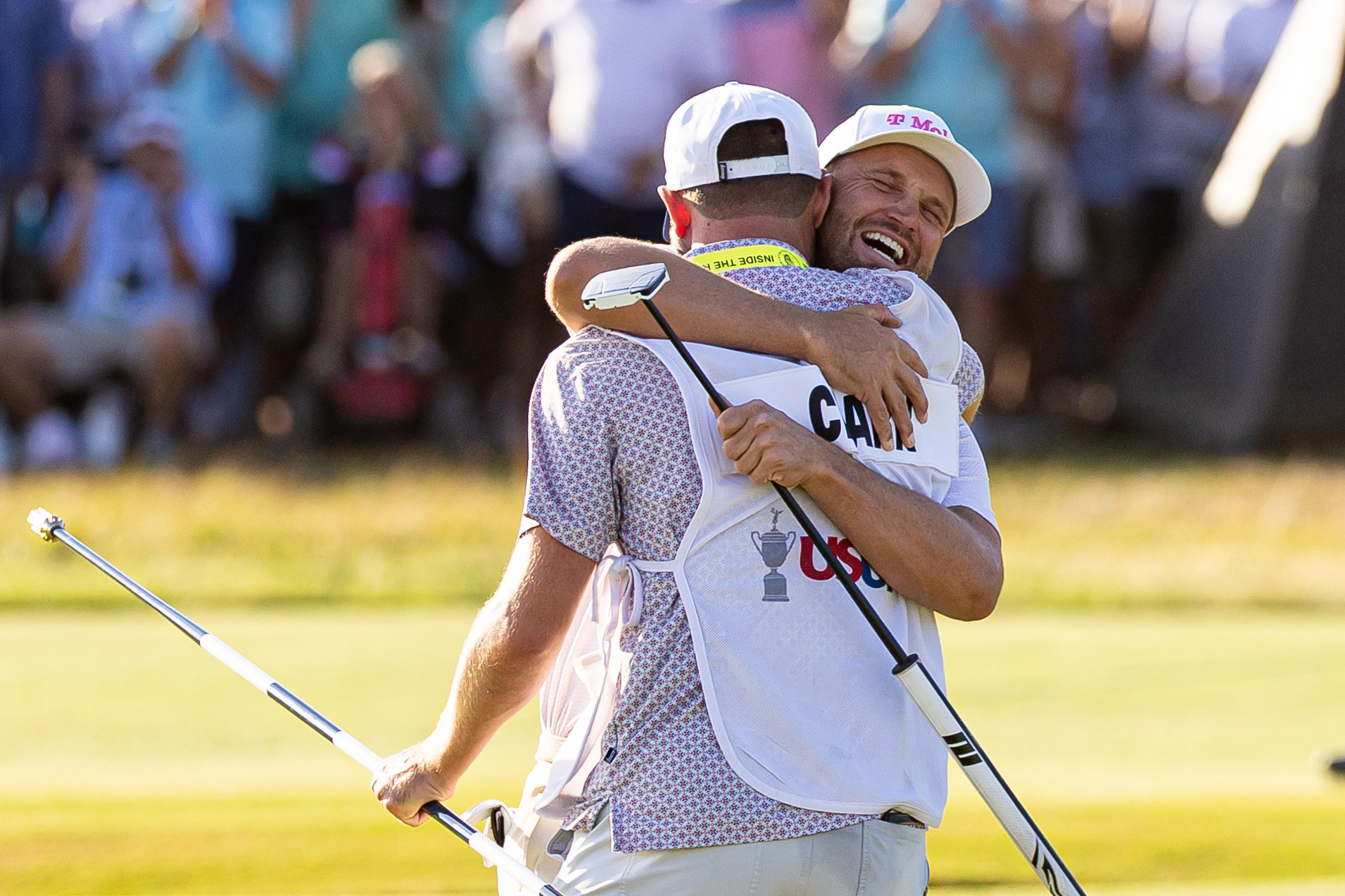 Wyndham Clark hugs his caddie David Pelekoudas as he is featured in our Travelers Championship First-Round leader prediction & odds.
