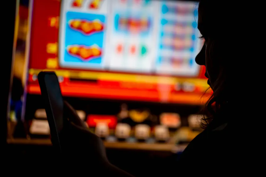 A woman plays an online gambling game on a smartphone in a staged scene as we look at the growth of sweepstakes casinos