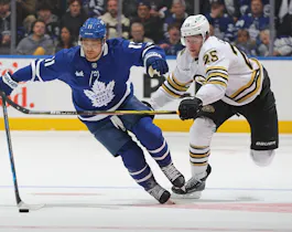 Brandon Carlo of the Boston Bruins skates to check Max Domi of the Toronto Maple Leafs in Game 3 of the 2024 Stanley Cup Playoffs, and we offer our top Bruins vs. Maple Leafs predictions and expert picks based on the best NHL odds.