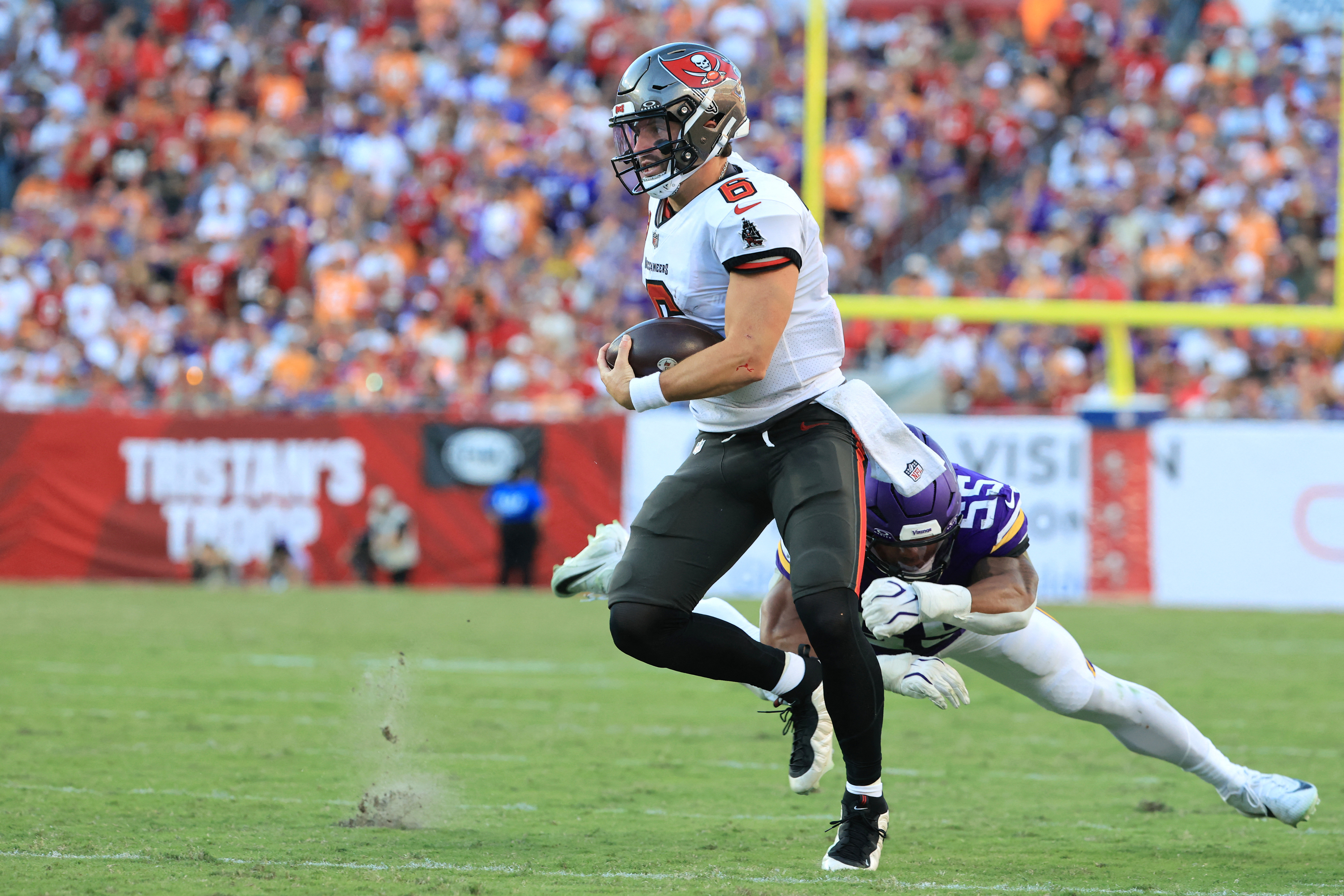 Tampa Bay Buccaneers quarterback Baker Mayfield (6) avoids a tackle as he is featured in our Buccaneers vs. Panthers prediction.