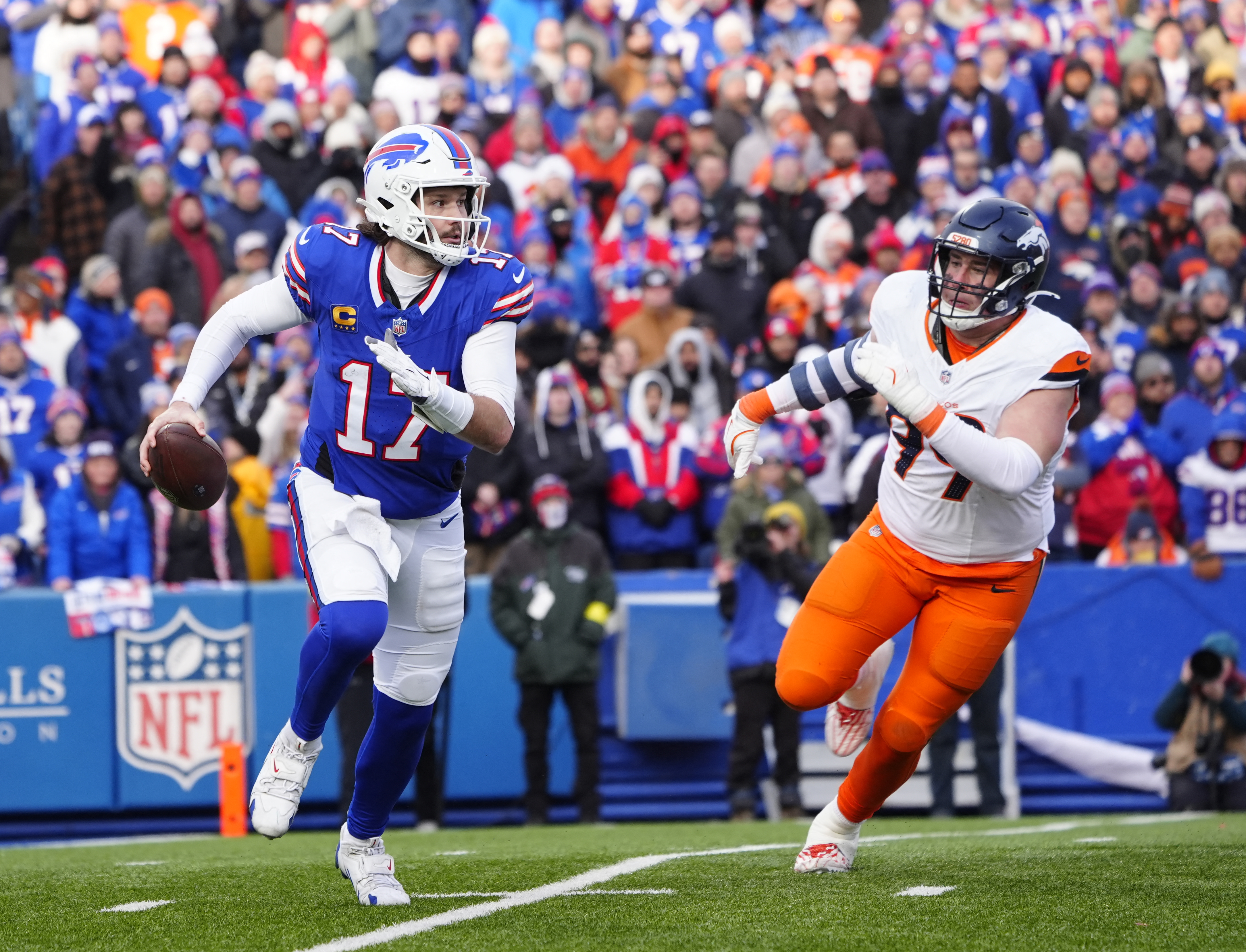 Buffalo Bills quarterback Josh Allen (17) runs for a gain as Denver Broncos defensive end Zach Allen (99) defends, as we make our NFL playoff bracket predictions entering the Divisional Round.