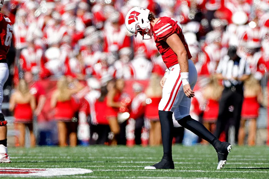 Graham Mertz of the Wisconsin Badgers limps toward the bench after being sacked in the fourth quarter against the Illinois Fighting Illini at Camp Randall Stadium on October 01, 2022 in Madison, Wisconsin.